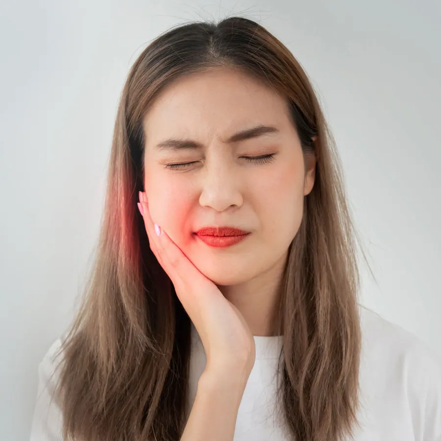 Woman holding her jaw with tooth pain