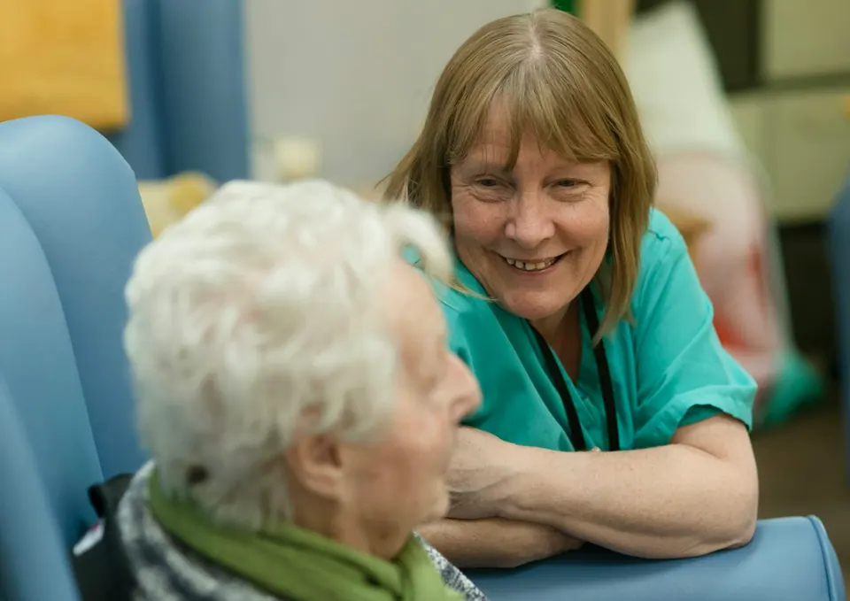 Dental team member talking warmly with an older patient